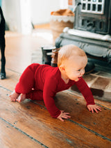 Baby crawling in long sleeve and long pants red indoors. #color_campfire