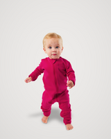 Toddler walking barefoot while wearing a deep pink Merino Wool Adventure Zippy romper with front zipper #color_peak pink