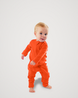 Toddler walking barefoot while wearing an orange-red Merino Wool Adventure Zippy romper with front zipper #color_poppy