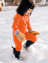 Child wearing Iksplor merino wool base layer leggings in dark pink while hiking  through snow #color_poppy