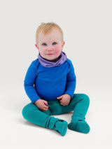 Iksplor baby wearing a blue merino wool bodysuit with a purple neck warmer and teal footed leggings #color_ocean