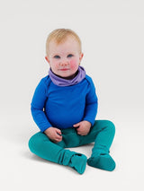 Iksplor baby wearing a blue merino wool bodysuit with a purple neck warmer and teal footed leggings #color_ocean