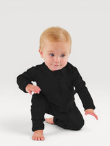 Iksplor infant wearing a black merino wool zip romper, designed for temperature regulation and comfort. #color_teton eclipse