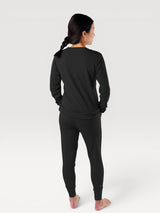 Woman wearing black Iksplor merino wool adventure joggers and matching long sleeve top from the back view #color_teton eclipse