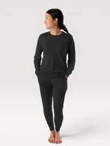 Woman wearing Iksplor black merino wool adventure joggers and matching long sleeve top in a slim fit style. #color_teton eclipse