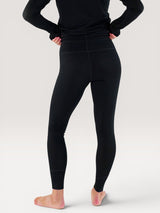 Back view of Iksplor black merino wool midweight leggings worn by a person on a neutral background. #color_teton eclipse