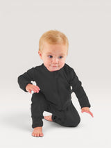 Iksplor infant wearing a black merino wool zip romper with long sleeves and snug cuffs on a light grey background #color_teton eclipse