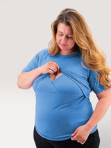 Woman wearing a blue Iksplor merino wool short sleeve nursing t-shirt with discreet front access #color_blue sky