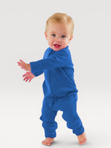 Iksplor baby wearing a vibrant blue merino wool zip romper with long sleeves and snug cuffs on a white background #color_ocean