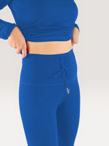 Iksplor royal blue merino wool midweight leggings with a high-waisted drawstring band worn by a woman. #color_ocean