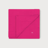 Iksplor fuchsia pink merino wool adventure blanket folded square with a small embroidered mountain logo detail. #color_peak pink