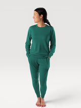 Woman wearing Iksplor green merino wool adventure joggers and matching long sleeve top in a slim fit style. #color_evergreen