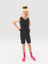 A young girl wearing an Iksplor black merino wool adventure tank top and matching shorts with bright pink socks. #color_teton eclipse