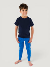 Young boy wearing a navy Iksplor merino wool t-shirt and bright blue joggers for outdoor play. #color_starry night - navy