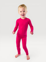 Child wearing Iksplor bright pink merino wool long-sleeve base layer top and matching leggings for cold weather #color_peak pink