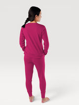 Woman wearing Iksplor magenta merino wool adventure joggers and matching long sleeve top from the back view. #color_peak pink