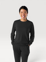 Woman wearing a black Iksplor Merino Wool Adventure Crew long-sleeve shirt with a comfortable, breathable fit. #color_teton eclipse