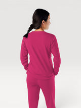 Woman wearing a fuchsia Iksplor Merino Wool Adventure Crew long-sleeve shirt from the back view #color_peak pink