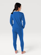 Woman wearing Iksplor royal blue merino wool long-sleeve top and slim-fit adventure joggers from behind #color_ocean
