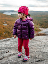 Child wearing Iksplor merino wool base layer leggings in dark pink while hiking on a rocky mountain trail #color_peak pink
