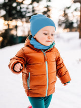 Toddler wearing a bright blue Iksplor merino wool neck gaiter and matching beanie in a snowy outdoor setting. #color_blue sky