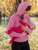 Iksplor dusty rose merino wool nursing sun hoodie worn by a mother holding her baby outdoors in autumn. #color_alpenglow