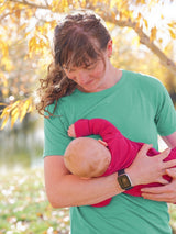 Iksplor green merino wool short sleeve nursing t-shirt worn by a mother holding her baby outdoors in autumn #color_meadow
