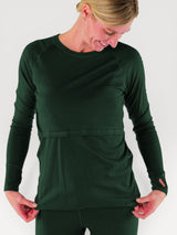 Iksplor dark green merino wool long sleeve nursing top with thumb holes on a woman smiling down #color_juniper