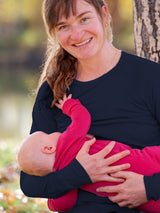 Mother wearing a navy blue Iksplor merino wool nursing top with thumb holes while breastfeeding her baby outdoors. #color_starry night