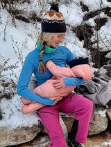 Iksplor merino wool nursing long sleeve top in blue worn by a mother breastfeeding her baby in a snowy outdoor setting. #color_blue sky