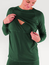 Iksplor forest green merino wool long sleeve nursing top with discreet access and thumb holes on a woman. #color_juniper