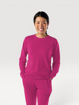 Woman smiling wearing a bright pink Iksplor Merino Wool Adventure Crew long-sleeve shirt and matching pants #color_peak pink