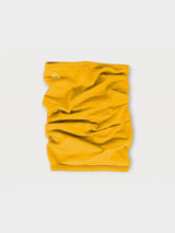 Iksplor mustard yellow merino wool neck gaiter with a small white mountain logo on a light grey background. #color_yellowstone