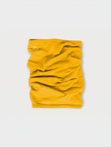 Iksplor mustard yellow merino wool neck gaiter with a small white mountain logo on a light grey background. #color_yellowstone