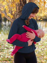 Iksplor navy blue merino wool nursing sun hoodie with UPF 50 protection worn by a mother holding her baby outdoors. #color_starry night