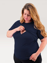 Woman wearing a navy blue Iksplor merino wool short sleeve nursing t-shirt with discreet front access #color_starry night