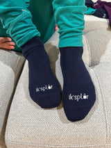 Iksplor navy blue merino wool and tencel blend trail socks with white logo on the toes worn by a child #color_basecamp