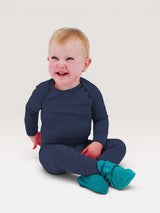 Happy baby wearing Iksplor navy blue merino wool long sleeve shirt and pants with teal booties #color_starry night