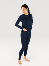 Iksplor woman wearing a navy blue merino wool long-sleeve baselayer top and matching leggings for cold weather. #color_starry night - navy