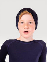 Iksplor child wearing a soft navy blue merino wool beanie, slim fit for comfort under helmets.