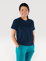 Woman wearing a navy blue Iksplor merino wool t-shirt with short sleeves, designed for comfort and temperature control. #color_starry night