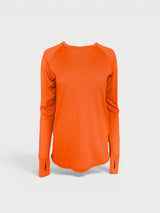 Iksplor bright orange merino wool long sleeve top with thumbhole cuffs and a curved hem. #color_poppy