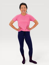 Iksplor woman wearing a bright pink short-sleeve merino wool t-shirt with navy leggings and purple socks #color_alpenglow