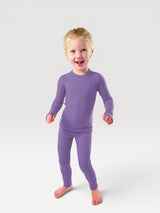 A happy child wearing a purple Iksplor merino wool long sleeve top and matching leggings, perfect for base layers.  #color_lilac