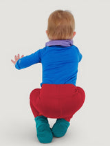 Toddler wearing Iksplor red merino wool leggings with a wide waistband and teal socks, back view. #color_campfire
