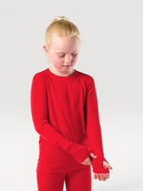 A child wearing a bright red Iksplor merino wool long sleeve top with thumbhole cuffs against a neutral background. #color_campfire