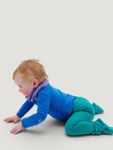 Baby crawling in Iksplor teal merino wool leggings with a wide waistband and blue long-sleeve base layer top #color_evergreen
