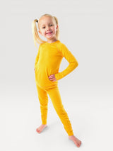 Young girl wearing bright yellow Iksplor merino wool long-sleeve base layer top and matching leggings #color_yellowstone
